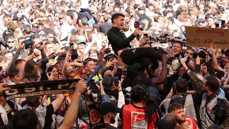 St. Pauli coach Fabian H..rzeler is lifted by fans who invaded the field after their team won 3-1 during a second division, Bundesliga soccer match between St. Pauli and VfL Osnabr..ck, at the Millerntor Stadium, in Hamburg, Germany, Sunday, May 12, 2024. (Christian Charisius/dpa via AP)