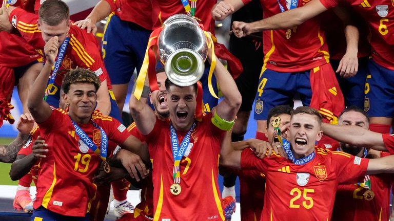 Spain's Alvaro Morata holds the trophy aloft