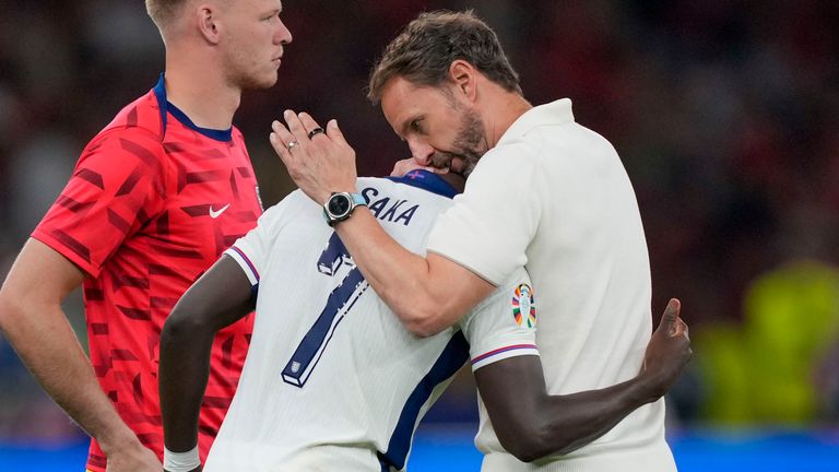 England's manager Gareth Southgate, right, comforts Bukayo Saka at the end of the final match between Spain and England at the Euro 2024 soccer tournament in Berlin, Germany, Sunday, July 14, 2024. (AP Photo/Martin Meissner)